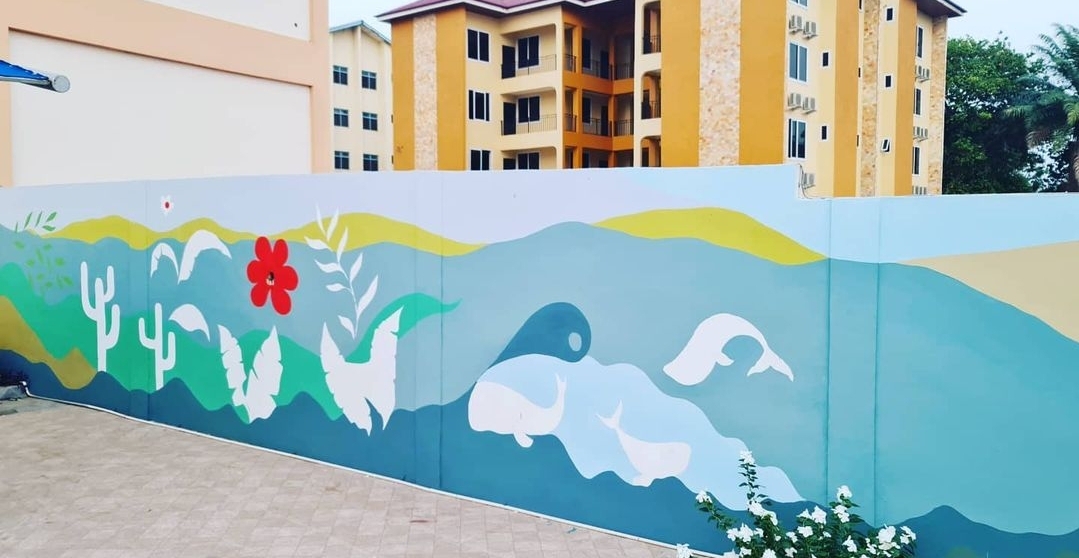 Large-scale public wall mural by Kizito Nii Amarh Amartey with stylised landscape and flora