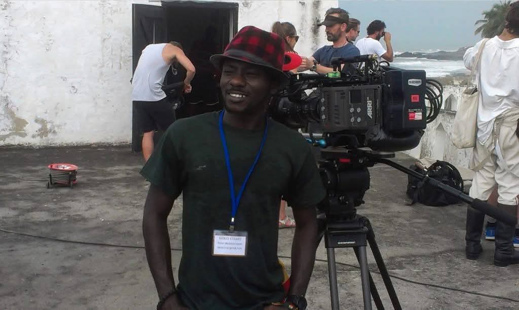 Prince Kojo-Hilton on location beside an ARRI camera during a feature film production in Ghana